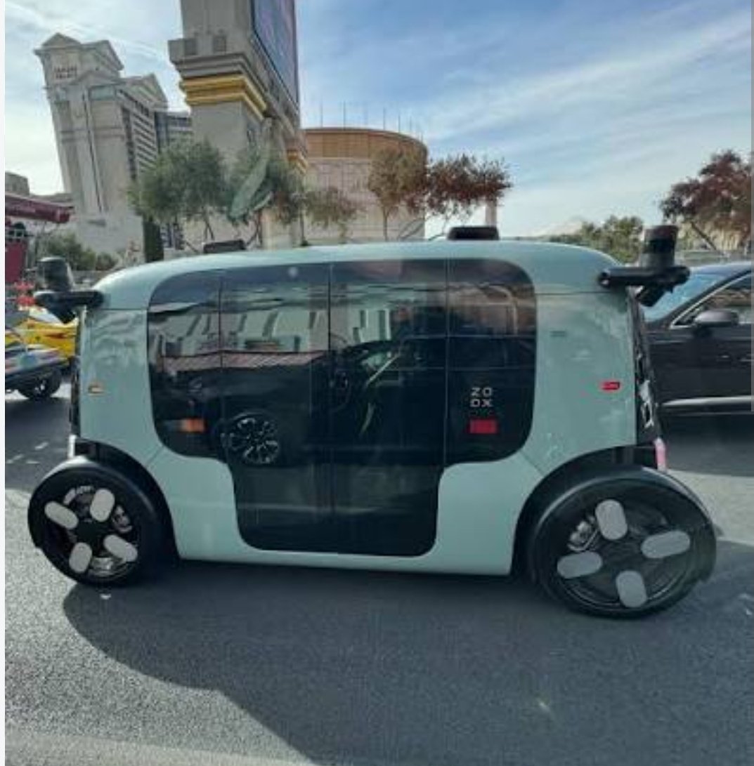 Zoox autonomous robotaxi electric vehicle on the road — purpose-built bidirectional AV pod with no steering wheel